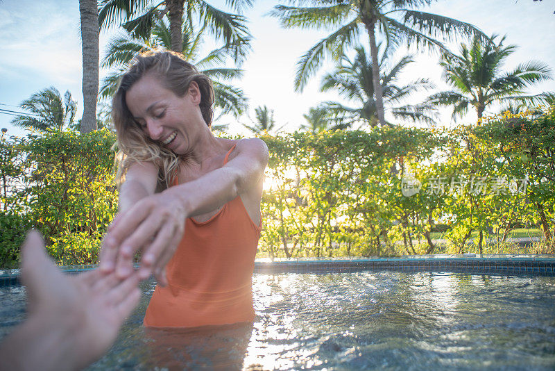 跟着我POV -夫妇在爱有乐趣。男朋友跟女朋友牵手在泰国户外的自然微笑享受地热温泉豪华度假村游泳池撤退